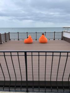 two orange chairs sitting on a boardwalk near the ocean at Elling Briz in Feodosia