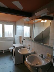 a bathroom with two sinks and a toilet at Ferienwohnung Yara Rödental in Rödental