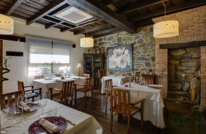un ristorante con tavoli e sedie e un muro di pietra di La Posada del Casar a Casar de Palomero