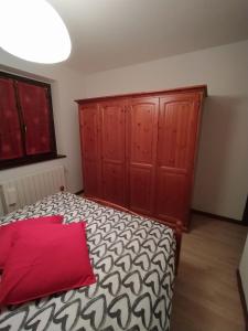 a bedroom with a bed with a red pillow at Bilocale con box a due passi dalle piste da sci in Colere