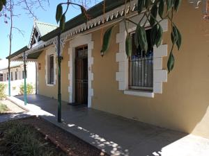 um edifício amarelo com uma porta e uma janela em Route 62 B&B em Robertson