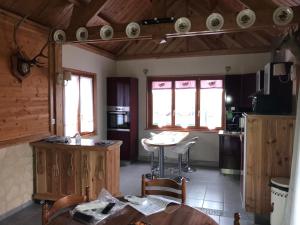 uma cozinha com mesa e cadeiras num quarto em Le chalet em Saint-Quentin-Lamotte-Croix-au-Bailly