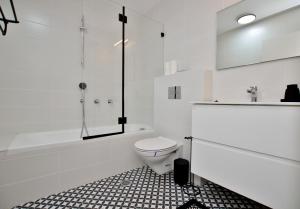 y baño blanco con aseo y bañera. en PRIME LOCATION HIGH STANDARD 3 ROOMS APT, en Tel Aviv