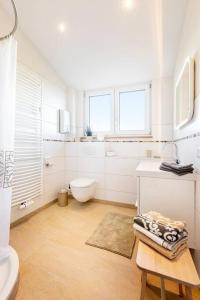 ein weißes Bad mit einem WC und einem Waschbecken in der Unterkunft Einfach schöne Ferienwohnung in Backnang