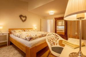 ein Schlafzimmer mit einem Bett, einem Tisch und einem Stuhl in der Unterkunft Einfach schöne Ferienwohnung in Backnang