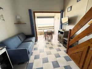 una sala de estar con un sofá y una mesa en Appartement T2 mezzanine vue mer avec piscine, en Saint-Cyprien
