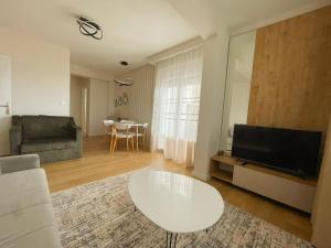 a living room with a white table and a television at Belvedere Apartments in Ulcinj