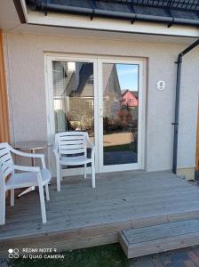a porch with two chairs and a sliding glass door at Avalon Studio. Comfy well equipped cosy studio. in Aviemore