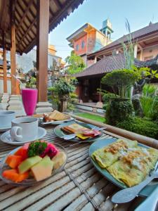 a wooden table with plates of food on it at Dika Accommodation Ubud in Ubud