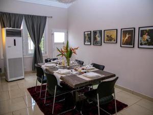 a dining room with a long table and chairs at Stunning 3-Bed House in Tema-Ahenfie Villa in Kwedonu