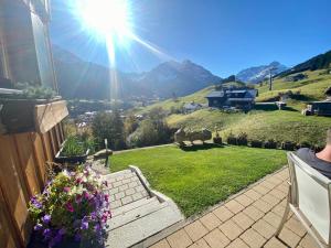 a view of the mountains from a house with flowers at bi dr Gondamaika in Hirschegg