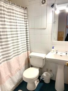 een badkamer met een wit toilet en een wastafel bij Hostal Playa Peñuelas in Coquimbo