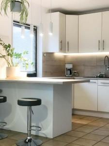 a kitchen with white cabinets and a counter with a stool at Holiday home Treinen Ramona in Riol