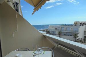 uma varanda com duas mesas e vista para o oceano em Cap d'Agde Naturist Héliopolis O 33 em Cap d'Agde