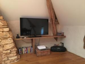 einen Flachbild-TV auf einem Regal in einem Zimmer in der Unterkunft Gîte écologique en vallée de la Dordogne Lotoise in Gignac