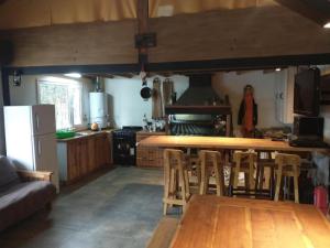 uma cozinha com uma mesa de madeira e cadeiras em Cabaña en Casa de Piedra em San Carlos de Bariloche
