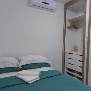 um quarto branco com uma cama com um espelho em Apartamento na praia de Jatiuca em Maceió