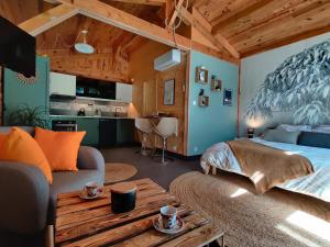 um quarto com uma cama, um sofá e uma mesa em Chalet, bain nordique (spa) dans le triangle noir em Quissac