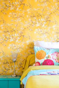 a bedroom with a bed with a yellow wall at Maison 1934 - Colmar Gare & Parking gratuit in Colmar