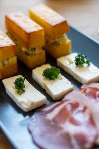 un piatto di formaggio e altri alimenti su un tavolo di Vista Mountain House a Kopaonik