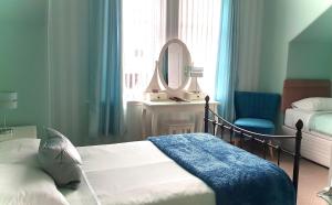 um quarto com uma cama, um espelho e uma cadeira em Dawn Break Guest House em Largs