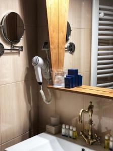 a bathroom with a blow dryer and a sink at Garni hotel Oblačinsko jezero in Oblačina