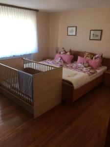 - une chambre avec un grand lit et des oreillers roses dans l'établissement Ferienhaus Störzel Wohnung A, à Morbach