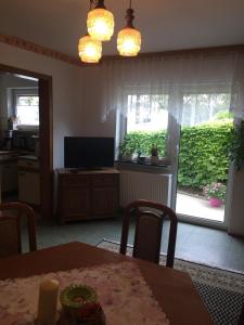 ein Esszimmer mit einem Tisch und eine Küche mit einem Fenster in der Unterkunft Ferienhaus Störzel Wohnung A in Morbach