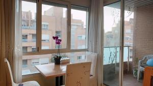 ein Zimmer mit einem Tisch und einem Fenster mit einer Blume darauf in der Unterkunft Alcobendas Cómodo y luminoso Un dormitorio in Alcobendas