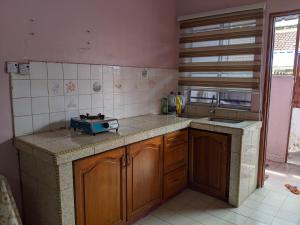 a kitchen with a stove and a counter top at Aryani Homestay in Kampong Kelemak