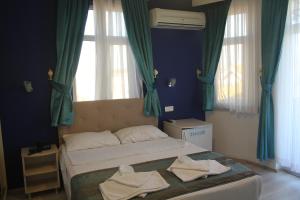 een slaapkamer met een bed met handdoeken erop bij Masal Hotel in Buyukada