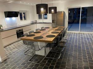 a large kitchen with a long wooden table and chairs at Gîte le belloy'Zo in Belloy sur Somme