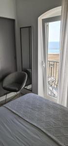 
a bed sitting in front of a window next to a window at Hotel Mar Bravo in Nazaré
