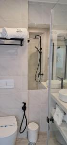 a white bathroom with a toilet and a shower at Hotel Mar Bravo in Nazaré