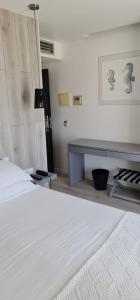 a bedroom with a white bed and a fireplace at Hotel Mar Bravo in Nazaré