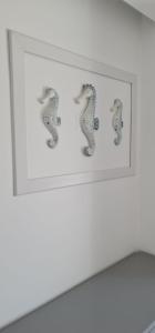 a framed picture of two seahorses on a wall at Hotel Mar Bravo in Nazaré
