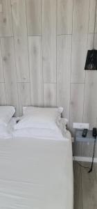 a white bed in a room with a wall at Hotel Mar Bravo in Nazaré
