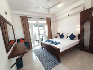 a bedroom with a bed and a large window at The Bamboo Tree Transit Hotel in Katunayake