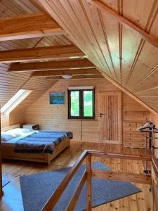 a log cabin bedroom with a bed and a window at Domek Salted Caramel in Żarnowska
