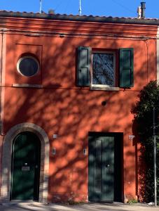 a red brick building with two doors and a window at La casetta rossa in Rimini