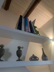 two white shelves with books and vases on them at La casetta rossa in Rimini
