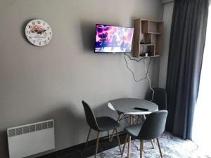 班斯科MH Apartments的一间有桌子、椅子和钟的餐厅