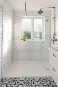 a bathroom with white subway tiles and a window at Authentieke vakantiewoning op 200 m van het strand in De Panne