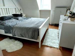a bedroom with a bed and two white rugs at Ferienwohnung am Salzsee in Bad Windsheim