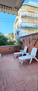 twee witte stoelen op een patio voor een gebouw bij Ca'del pescatore in Sanremo