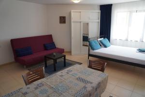a bedroom with a bed and a couch and a table at Apartments Paskalina in Byala