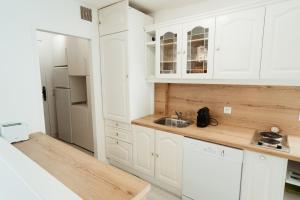 a kitchen with white cabinets and a sink at Les Lodges de Saint Cassien 2 in Montauroux