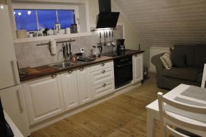 una cucina con lavandino, piano cottura e divano di Solhem Terrassen ad Arvika