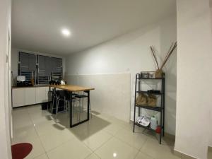 a kitchen with a wooden table and a counter at Desaru Happy Guest House D in Desaru