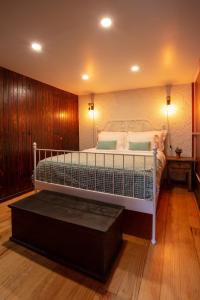 a bedroom with a white bed with a wooden wall at Madeira Black Sand House by Stay Madeira Island in Seixal